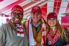 Three smiling friends wearing gear that reads "IU alumni"